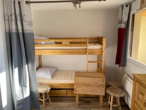 a bunk bed with two stools in a room at Samoëns 1600 les cimes in Samoëns