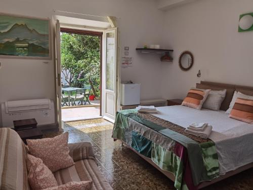 - une chambre avec un lit et une porte coulissante en verre dans l'établissement Il Giardino Di Tatiana Rooms & Breakfast, à La Maddalena