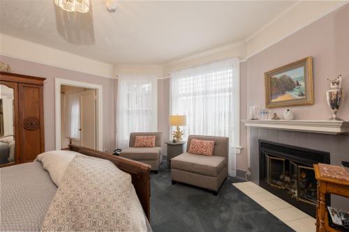 a living room with a bed and a fireplace at Nantucket Whale Inn, Half Moon Bay in Half Moon Bay