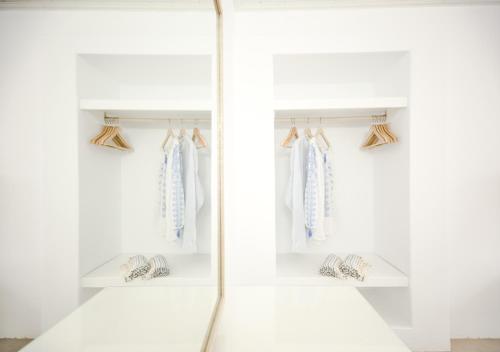 a walk in closet with white walls and shelves at Agnandi Cielo in Tourlos