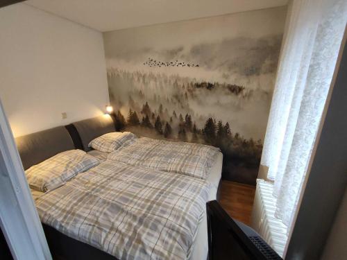 ein Schlafzimmer mit einem Bett und einem Wandgemälde in der Unterkunft Ferienwohnung Marx (K1 Blick) Willingen in Willingen