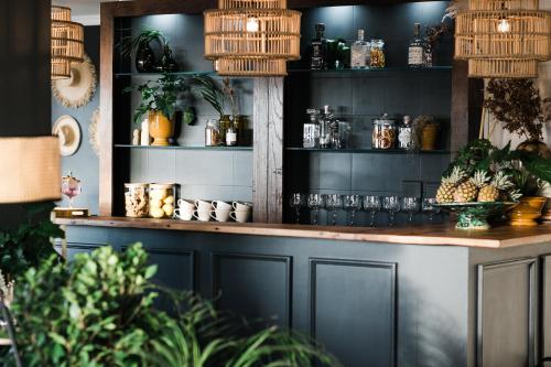 a bar in a restaurant with plants and glasses at Royal Boutique Hotel in Cape Town