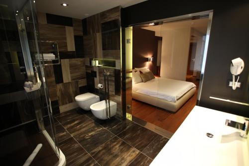 a bathroom with a bedroom with a bed and a shower at Hotel IN in Međugorje