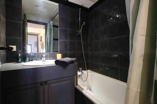 un bagno con vasca, lavandino e vasca da bagno di CENTRE VILLE Appartement 75m2, avec 3 chambres a Carcassonne