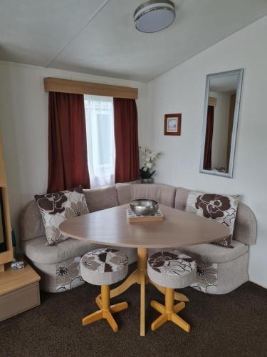 a living room with a table and a couch at Carmels Caravan Borwick Lakes in Carnforth