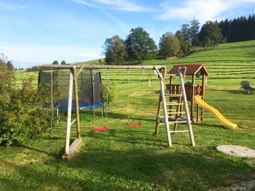 een speeltuin met een glijbaan en een schommel bij Ferienwohnung Reisach in Lindenberg im Allgäu