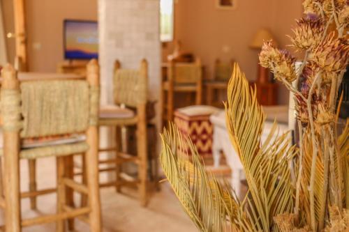 - un salon avec des chaises et un vase fleuri dans l'établissement Upupa de l’Atlas, à Marrakech