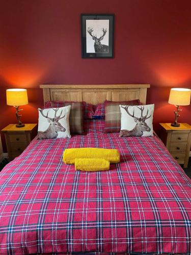 a bed with two deer heads and a yellow pillow on it at Haste Ye Back in Inverness