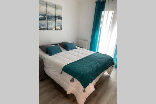 a bedroom with a large bed with a green blanket at STUDIO VUE MER /PARKING PRIVATIF in Saint-Raphaël