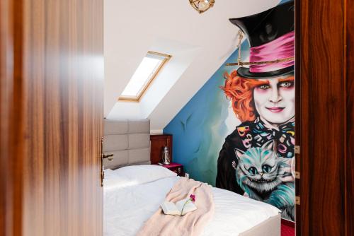 a bedroom with a painting of a woman on the wall at Petra Inn Apartments in historical palace Bratislava in Bratislava