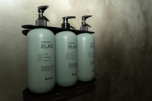 a group of three white hair products on a shelf at Converted Water Tower in Grindavík