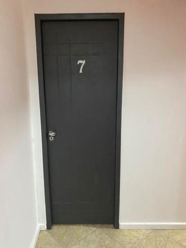 a black door with the number seven on it at Ipanema Club Hostel in Rio de Janeiro