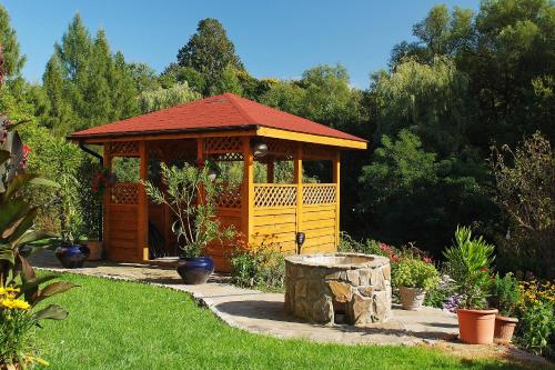 a wooden gazebo in the middle of a garden at Agroturystka u Basi in Pietrzykowice
