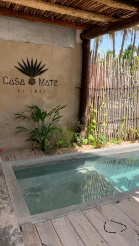 a swimming pool in front of a villa with a fence at Casa Mate BeachFront Cabañas El Cuyo in El Cuyo