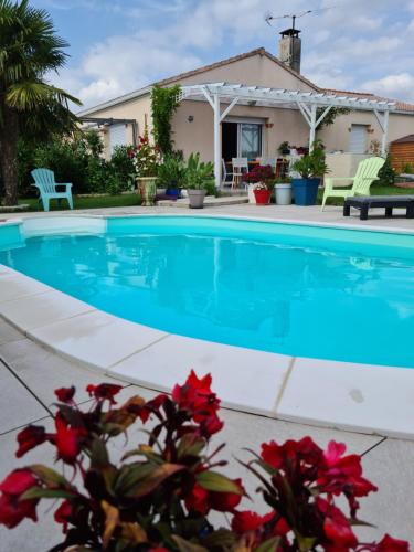 a swimming pool in front of a house at Studio Le Pavachon 2 à 3 couchages, piscine familiale chauffée, 3 min du Puy du Fou Les Epesses in Les Épesses
