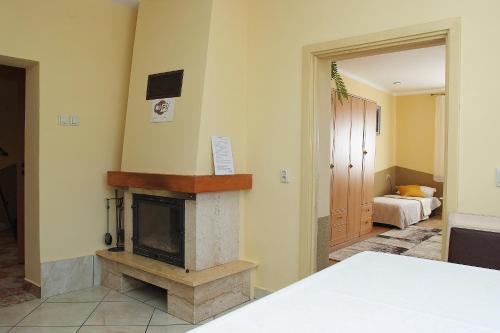 a living room with a fireplace and a bedroom at Agroturystka u Basi in Pietrzykowice