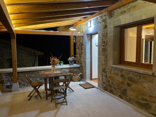 a dining room with a table and a stone wall at Los Toriles in Los Espejos de la Reina