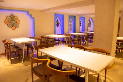 a restaurant with tables and chairs and purple lighting at VANCII Hotel in Chefchaouene