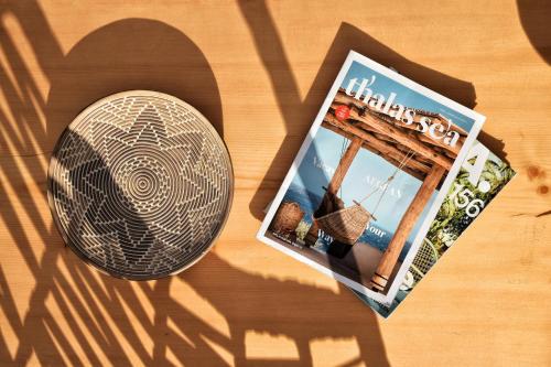 a magazine sitting on a table next to a book at Angelos Design Suites in Patitiri