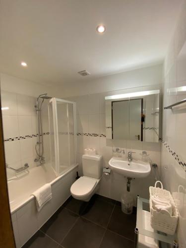 La salle de bains est pourvue de toilettes, d'une baignoire et d'un lavabo. dans l'établissement CENTRO Appartamento Ascona, à Ascona