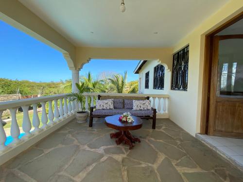 a balcony with a couch and a table at MASKANI Villa in Galu