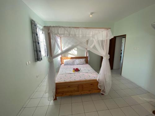 a bedroom with a canopy bed with flowers on it at MASKANI Villa in Galu