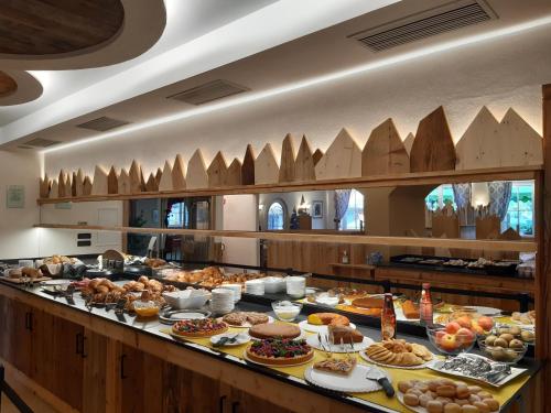 una linea a buffet con molti tipi di cibo diversi di Hotel El Pilon a Pozza di Fassa