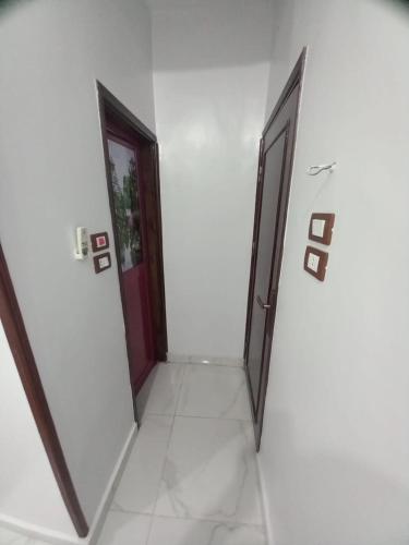 two doors in a room with white walls at Jamaica Guest House in Aswan