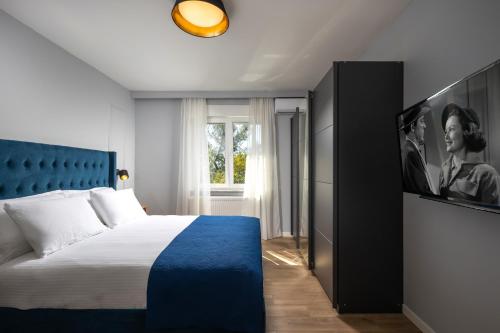 een slaapkamer met een groot bed en een televisie bij Blue Allure Apartment in Rijeka