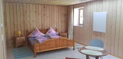 トートナウにあるFerienwohnung Natururlaub Muggenbrunnのベッドとテーブルと椅子のある寝室