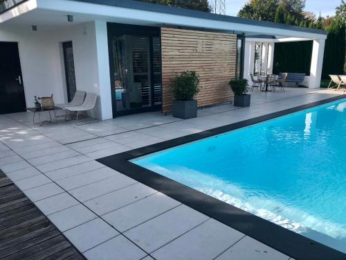 a swimming pool with a patio and a house at Guesthouse Passau in Passau