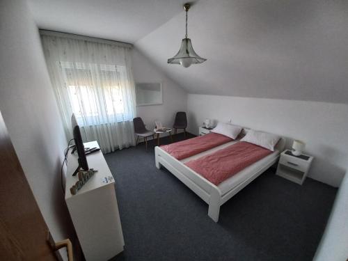 um quarto com uma cama e uma televisão em Apartmani Denis em Dubrave Gornje