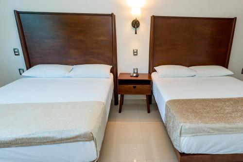 a hotel room with two beds and a table at LA LOMA SUITES in Ixtapa
