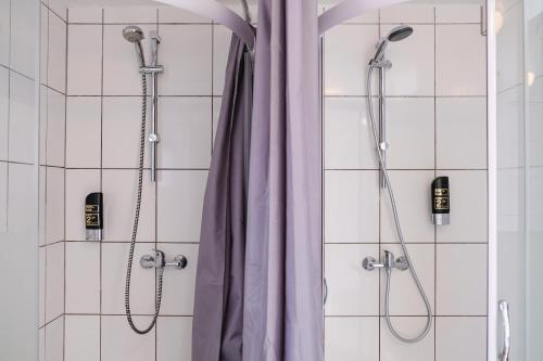 y baño con ducha y cabezal de ducha. en Hostel City Süd en Hamburgo