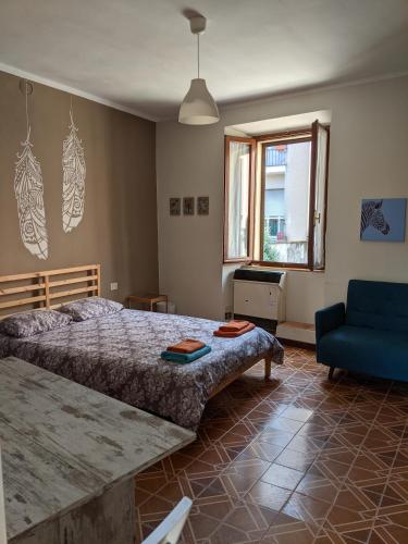 ein Schlafzimmer mit einem großen Bett und einem blauen Sofa in der Unterkunft Pallanza centro in Verbania