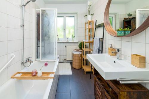 a bathroom with a tub and a sink and a mirror at EG Rechts -Wunderschöne 80m² große 3-Zimmer City Wohnung nähe Salzburg in Freilassing