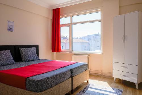 a bedroom with a bed with a red curtain and a window at 3+1 NEW Kadıköy Istanbul entire flat furnished apartment for rent in the heart of Kadikoy! in Istanbul