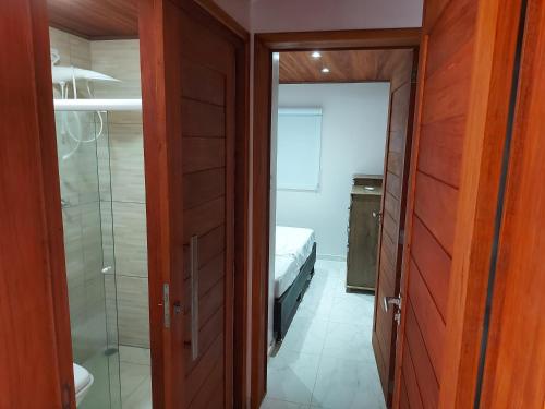 a bedroom with a bed and a shower and a door at Casa Barra de São Miguel 4 quartos - BarraMar in Barra de São Miguel