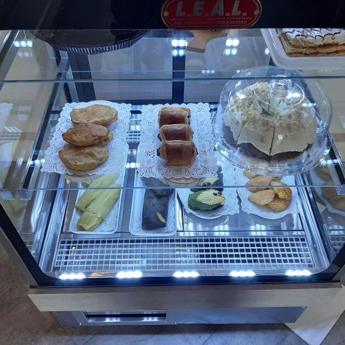 a display case with different types of pastries and cakes at Adamas House Hotel Boutique in Quito