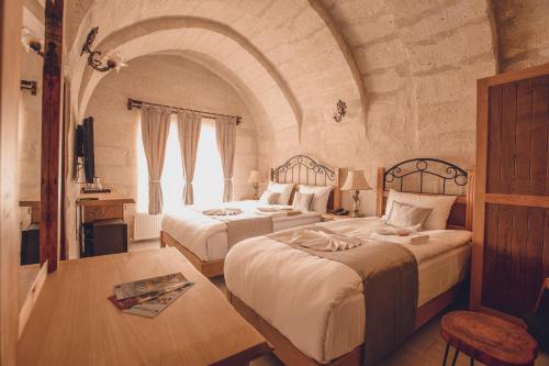 two beds in a room with an archway at Rose Valley Hotel in Goreme