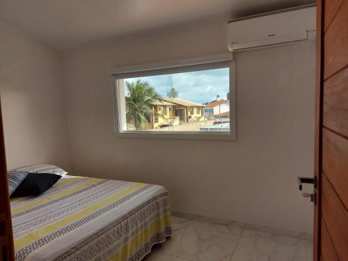 a bedroom with a window with a bed in it at Casa Barra de São Miguel 4 quartos - BarraMar in Barra de São Miguel
