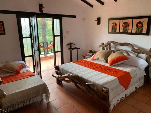 a bedroom with two beds and a cross on the wall at Marboa Campestre in Curití