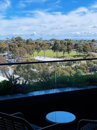 a view of a park from a balcony with a table at Skygarden Luxury Condo in Glen Waverley