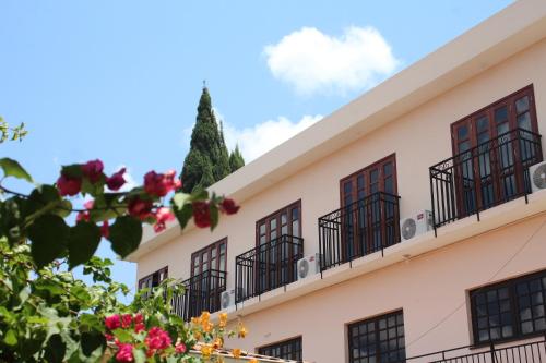 a building with windows and flowers in the foreground at Pousada Solar Do Triunfo in Triunfo