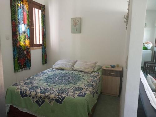 een slaapkamer met een bed met een quilt bij LA CABAÑA DE HUERTAMAR in Zorritos