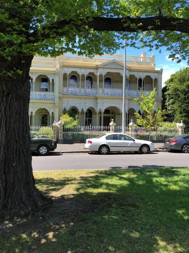 a white car parked in front of a large building at East Melbourne City Studio - Amazing Location & Sunny Charm in Melbourne