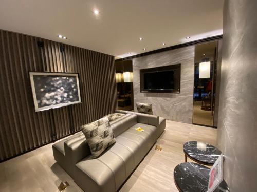 a living room with a couch and a television at Politan Breeze, Chaophraya River view in Ban Sai Ma