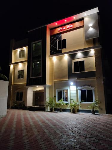 a building with a sign that reads hotel wife at night at Hotel Wins in Kanyakumari