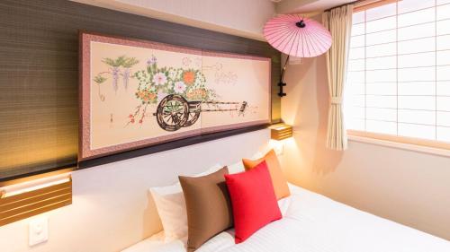 a bedroom with a bed with a painting above the headboard at Kyoto Inn Gion The Second in Kyoto