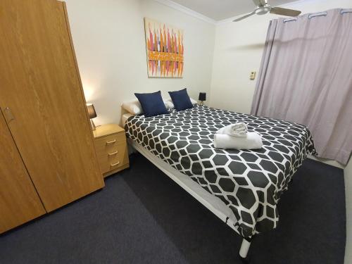 a bedroom with a black and white bed and a dresser at Perth City Apartment Hotel in Perth